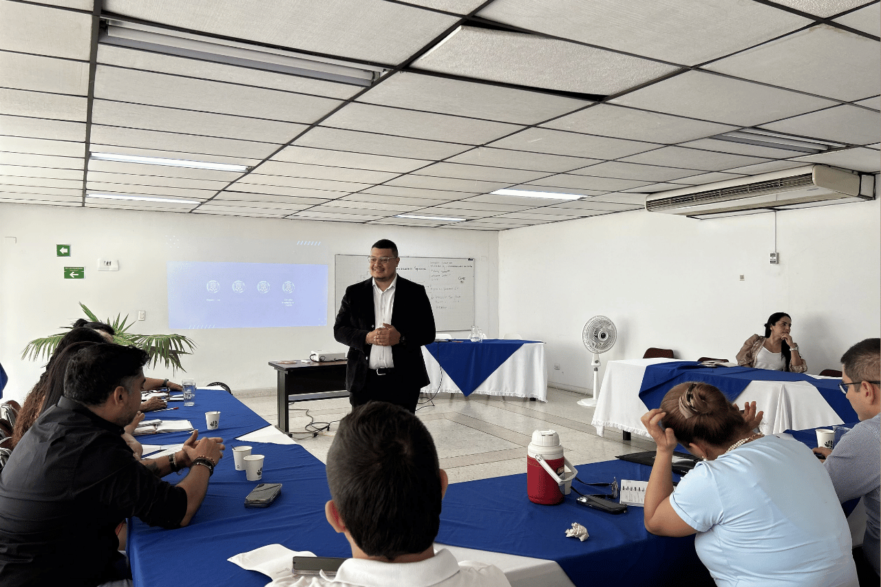 Expositor de Russell Bedford durante una capacitación empresarial sobre el Informe 75 ante un grupo de asistentes en una sala de reuniones.